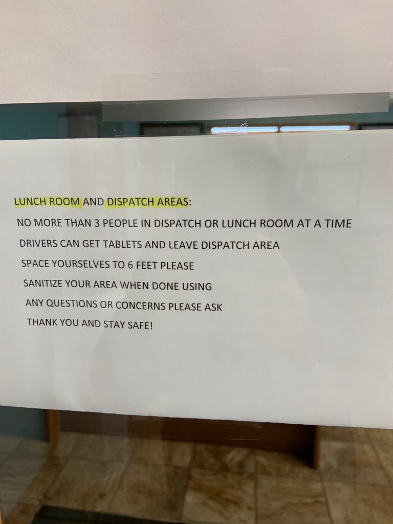 Sign that says "Lunch room and dispatch areas" (highlighted in yellow highlighter). "No more than 3 people in dispatch or lunch room at a time. Drivers can get tablets and leave dispatch area. Space yourselves 6 feet please. Sanitize your area when done using. Any questions or concerns please ask. Thank you and stay safe!"