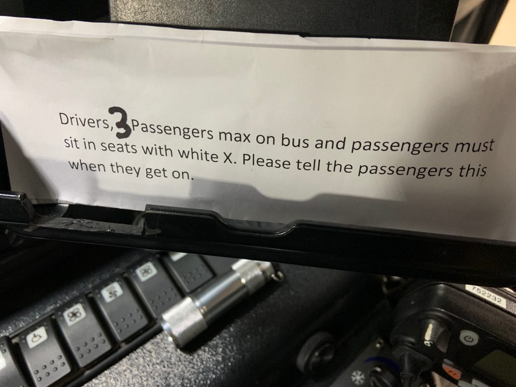 Sign that reads "Drivers, 3 Passengers max on bus and passengers must sit in seats with white x. Please tell the passengers when they get on."