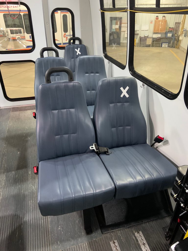 seats display x's indicating spaced seating on a UCAP bus