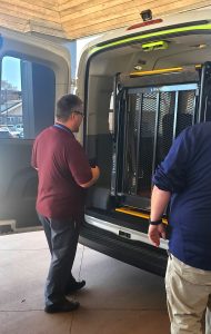 Image of man inspecting a lift at the back of a shuttle bus